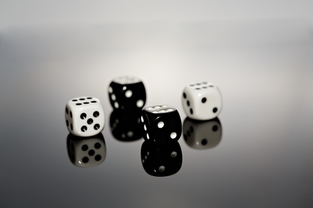 Four dice reflecting on surface.の写真素材