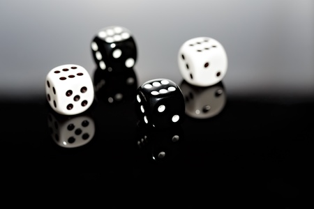 Four dice reflecting on surface.の写真素材