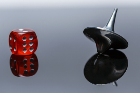 Whirligig and dice with reflection on a dark background