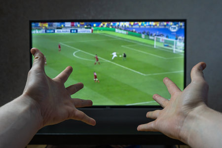Man watch football on TV with emotional hands gestures