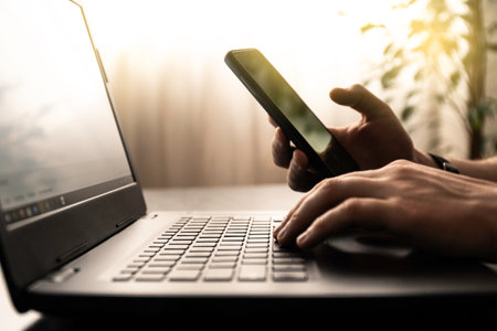 Man use smartphone and laptop in office or at home.の写真素材