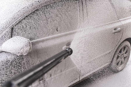 Contactless  car wash self service system. Washing dirty car in car wash station with foamの写真素材