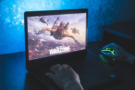 Call of Duty: Warzone is a free-to-play battle royale video game. Video computer game. Man play video game on laptopのeditorial素材