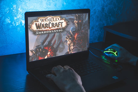 World of Warcraft is a massively multiplayer online role-playing game. Video computer game. Man play video game on laptopのeditorial素材