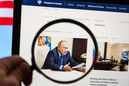 Vladimir Putin the president of Russian federation on the news. Looking through magnifying glassのeditorial素材
