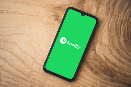 Spotify application on smartphone. Wooden background. Top angle shotのeditorial素材