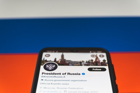 Russia and Ukraine war. Russia twitter account on smartphone. Russian flag in backgroundのeditorial素材