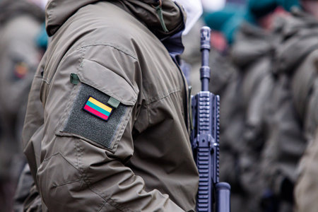 Lithuanian NATO soldier holding gun.  Close up shot of Lithuania flag on soldier uniform. Ukraine...