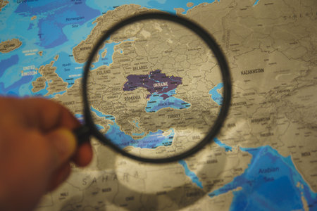 Ukraine on map. Ukraine through magnifying glass on paper map. Ukraine in Europe near Russia borderのeditorial素材