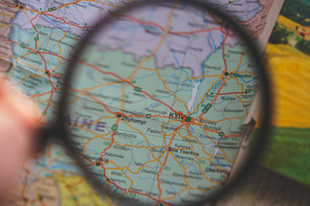 Ukraine on map. Ukraine through magnifying glass on paper map. Ukraine in Europe near Russia borderのeditorial素材