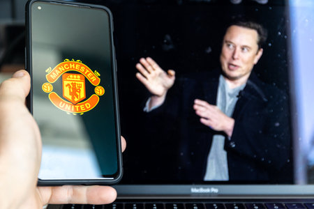Manchester , United Kingdom - August 17, 2022: Manchester United football club and Elon Musk in backgroundのeditorial素材
