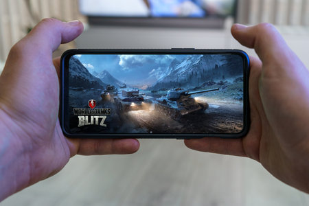Playing World of Tanks blitz mobile game. Point of view World of tanks football game on smartphoneのeditorial素材