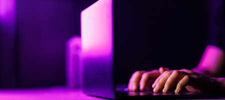 Man hands and Laptop on modern purple color environment. Copy space on black background. High quality photoの写真素材