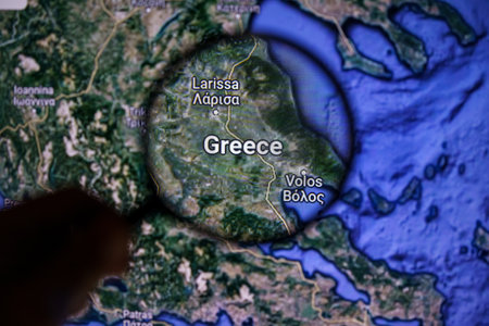 Greece on wildfire. Greece on maps through magnifying glassのeditorial素材