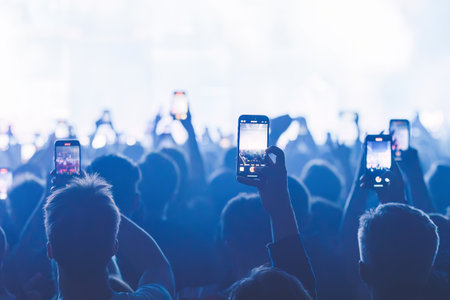 People taking pictures and recording at the big concert. Close-up shot. Streaming at the concert. High quality photoの写真素材