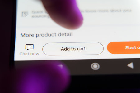 Close up of white Add to cart button on smartphone screen with users fingers above.