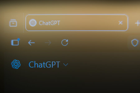 Close up of a computer screen showing a ChatGPT browser tab and AI logo on a warm golden background, representing artificial intelligence technology, machine learning, and future of digital communication.のeditorial素材