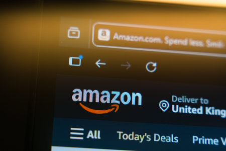 Amazon homepage displayed on a computer screen with the official logo and browser tab in a warm golden light, representing global e-commerce, online shopping, and digital retail marketplace.のeditorial素材
