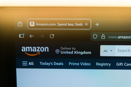 Amazon homepage displayed on a computer screen with the official logo and browser tab in a warm golden light, representing global e-commerce, online shopping, and digital retail marketplace.のeditorial素材