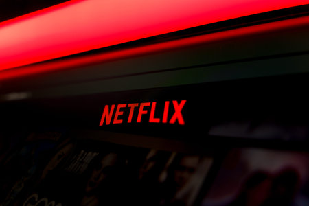 Close up of a Netflix streaming service interface on a computer screen featuring the official red logo against a dark background with vibrant red lighting, representing online video entertainment.のeditorial素材