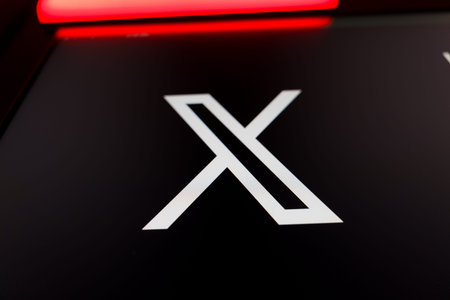 Close up of the X social media logo formerly known as Twitter on a black screen with vibrant red light streaks, representing modern digital communication, networking, and microblogging.のeditorial素材
