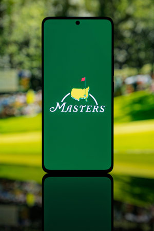 Smartphone displaying The Masters golf tournament logo on a green screen, set against a blurred...