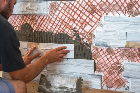 Installing the tiles on the wall.の写真素材