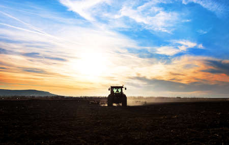 Farm machinery spraying insecticide to the green field.の写真素材