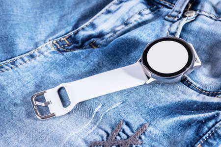 Smart watch concept on matte on blue jeans background.