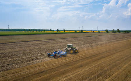 Varna, Bulgaria - Jul 09, 2020 Ploughing a field with John Deere 7730 tractor. Top view of agricultural industrial tractor.のeditorial素材