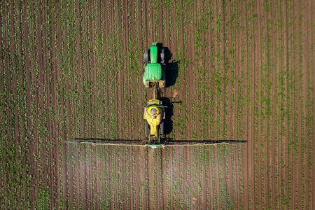 Vetrino, Bulgaria - June 6, 2021 Aerial image of tractor spraying young crop in springtime in fieldwith John Deere 6930 tractor. John Deere was manufactured in 1995-1999 and it has JD 7.6L or 8.1L 6-cのeditorial素材