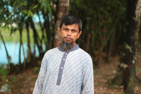 Bangladesh, Rangpur- July 03, 2021. An old man is standing and looking on Cameraのeditorial素材