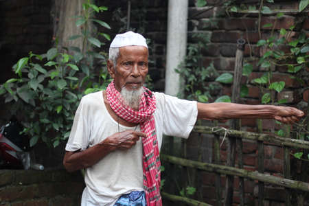 Bangladesh, Rangpur- July 03, 2021. An old man is standing with his one hand outstretchedのeditorial素材