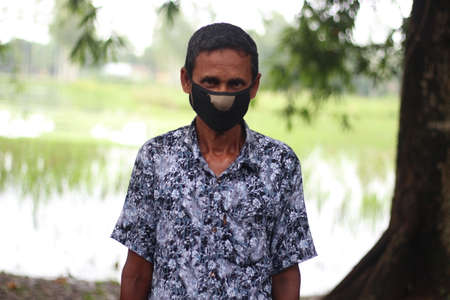 Bangladesh, Rangpur- July 03, 2021. A middle-aged man is standing wear the maskのeditorial素材