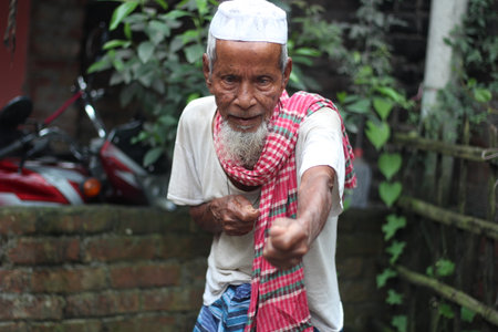 BaBangladesh, Rangpur- July 03, 2021. An old man is standing pose like a freedom fighterのeditorial素材