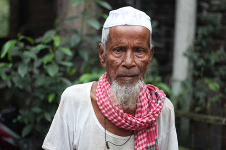 Bangladesh, Rangpur- July 03, 2021. An old man is standing and looking on Cameraのeditorial素材