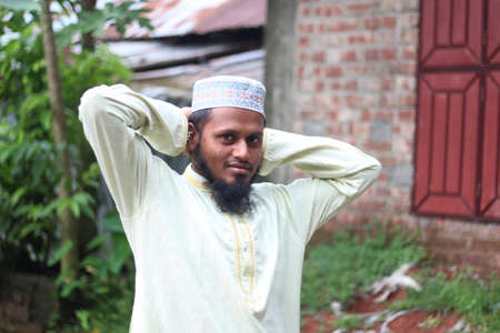 Bangladesh, Rangpur- July 03, 2021. A boy has two hands behind his head and the background behind him blurredのeditorial素材