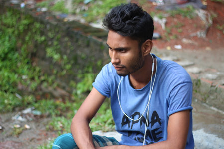 Bangladesh, Rangpur- July 03, 2021. A boy is sitting upset