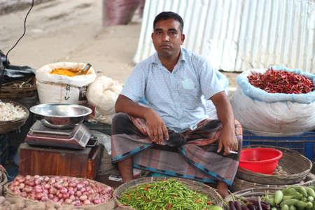 Bangladesh, Rangpur- July 03, 2021. A young person sitting his shop on the marketのeditorial素材