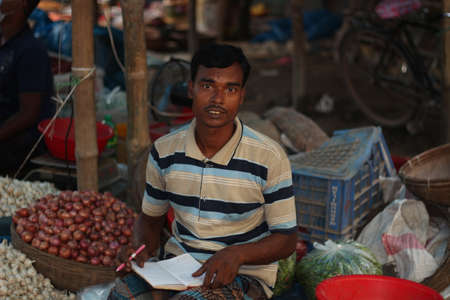 Bangladesh, Rangpur- July 03, 2021. A young person sitting his shop on the marketのeditorial素材