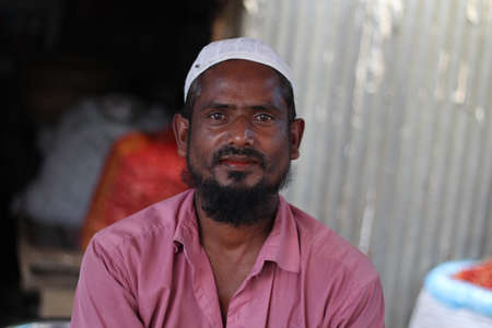 Bangladesh, Rangpur- July 03, 2021. A bearded person sitting on the marketのeditorial素材