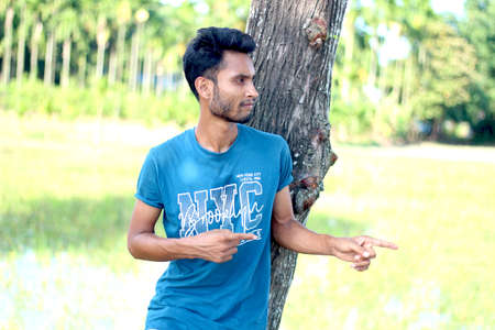 Bangladesh, Rangpur- July 12, 2021. A boy standing and showing his two hands and finger and his behind blur backgroundのeditorial素材