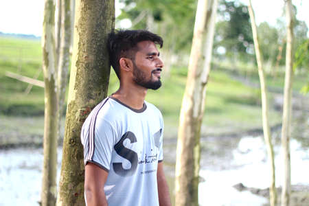 Bangladesh, Rangpur- July 12, 2021. A boy standing with upset and his behind blur background