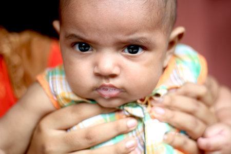 Bangladesh, Rangpur- July 02, 2021. A small baby looking camera and behind the background blurのeditorial素材