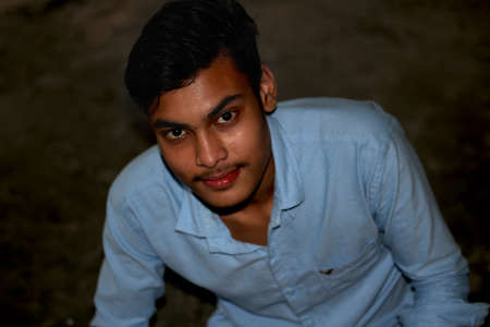 Bangladesh, Rangpur- July 02, 2021. A boy sitting In the evening and his behind Darkのeditorial素材