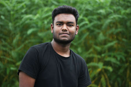 Bangladesh, Rangpur- July 02, 2021. A boy standing wearing a black t-shirt and his behind blur backgroundのeditorial素材
