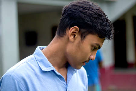 Bangladesh, Rangpur- July 02, 2021. A boy standing wearing a blue t-shirt and his behind blur backgroundのeditorial素材