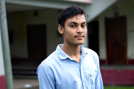 Bangladesh, Rangpur- July 02, 2021. A boy standing wearing a blue t-shirt and his behind blur backgroundのeditorial素材