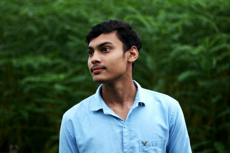 Bangladesh, Rangpur- July 02, 2021. A boy standing wearing a blue t-shirt and his behind blur backgroundのeditorial素材