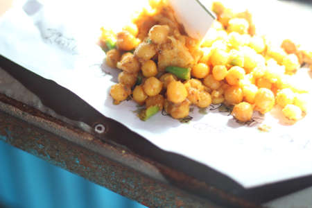 Street food with raw chili and yellow gram and white paper background